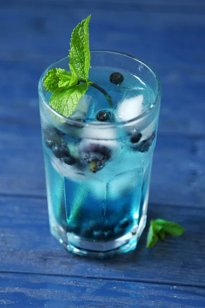 Copa de refrescante bebida fría de verano con bayas y cubitos de hielo en la mesa de cerca — Foto de Stock