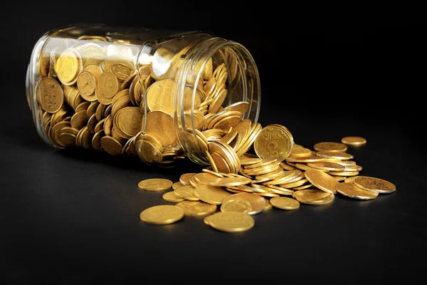 Glass jar with coins on dark background — Stock Photo, Image