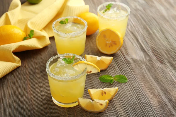 Стаканы лимонного сока на деревянном столе, крупным планом — стоковое фото