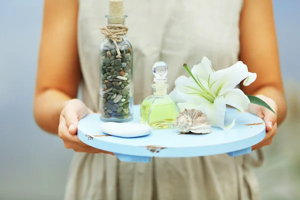 Mãos femininas com bandeja de produtos de spa — Fotografia de Stock