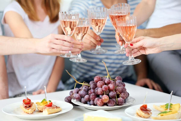 Friends hands with glasses of wine and snacks — Stock Photo, Image