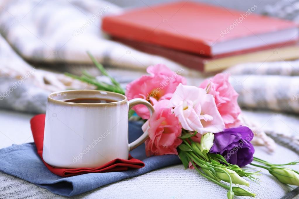 Csésze kávé, virágok, könyvek a szobában kanapé közelében — Stock Fotó ©  belchonock #86023366