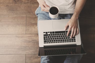 dizüstü bilgisayar ve kahve odası katta oturan genç adam