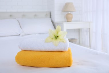 Freshly laundered fluffy towels in bedroom interior clipart