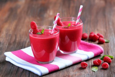 Ahşap masa üzerinde çilek ile Ahududu milkshake bardak yakın çekim