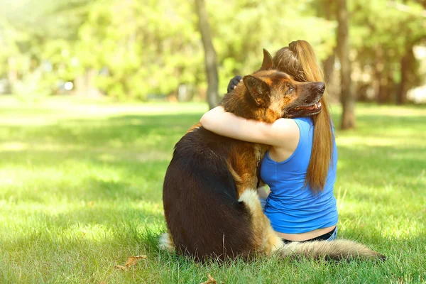 Schönes junges Mädchen mit Hund im Park — Stockfoto