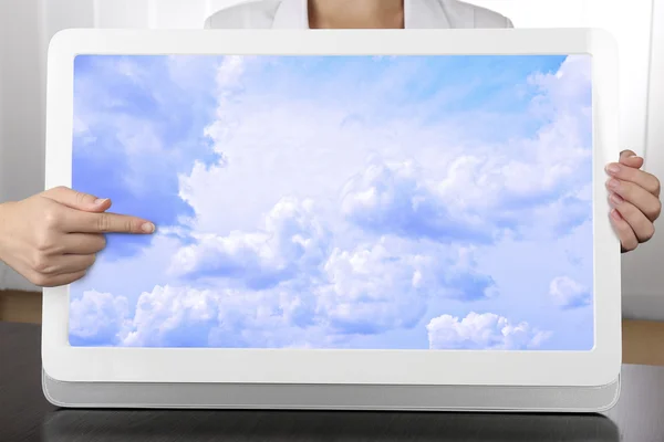 Mãos segurando tablet PC com o céu na tela. Conceito de computação em nuvem — Fotografia de Stock