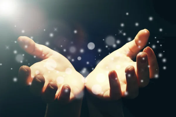 Luz nas mãos humanas no escuro, conceito milagroso — Fotografia de Stock