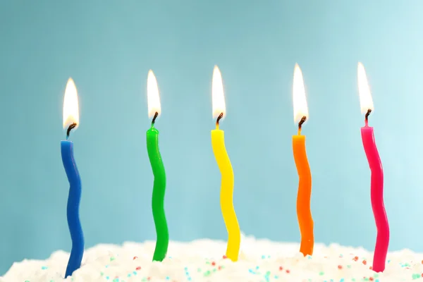 Торт на день рождения со свечами на цветном фоне — стоковое фото