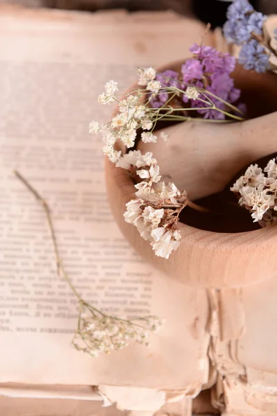 Old book with dry flowers in mortar close up — Stock Photo, Image