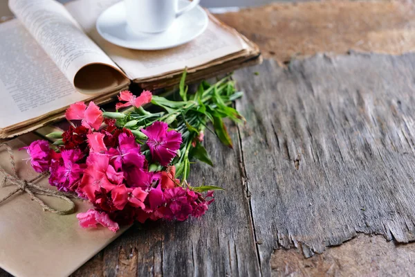 Old book with beautiful flowers and envelopes on wooden table close up — Stock Photo, Image