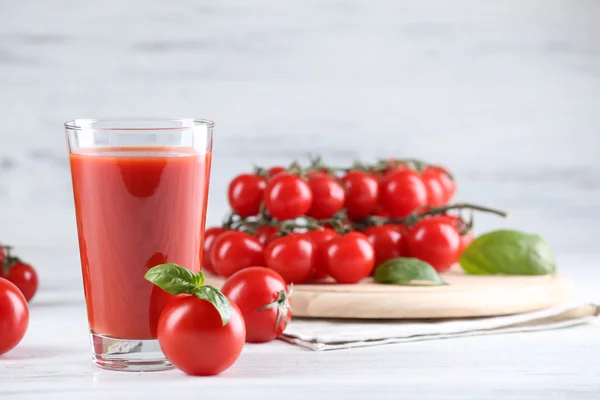 Glas tomatjuice med grönsaker på träbord nära håll — Stockfoto