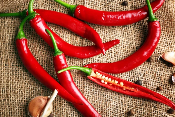 Peperoni rossi piccanti con spezie in tavola da vicino — Foto Stock