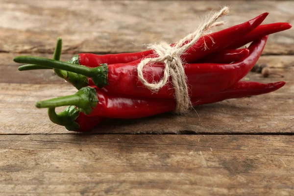 Red hot peppers med kryddor på träbord nära håll — Stockfoto