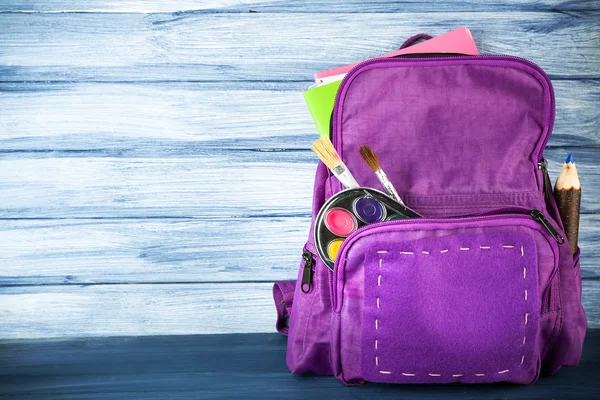 Ahşap arka plan üzerinde okul sırt çantası — Stok fotoğraf