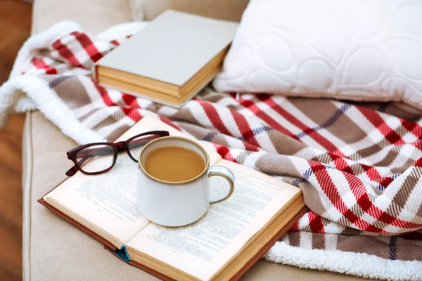 Φλιτζάνι καφέ με βιβλίο στον καναπέ στο καθιστικό — Φωτογραφία Αρχείου
