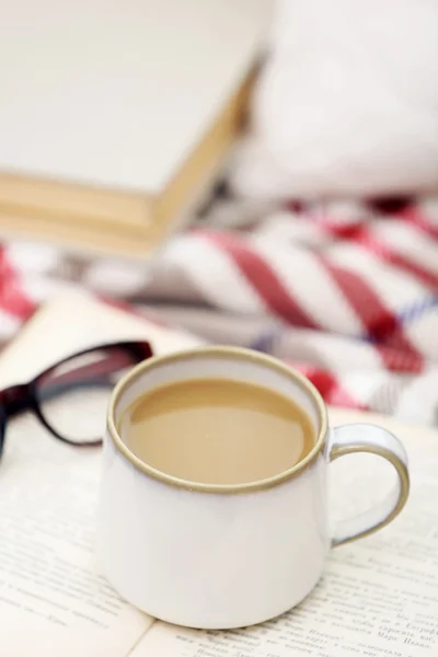 Taza de café con libro en sofá en la sala de estar — Foto de Stock