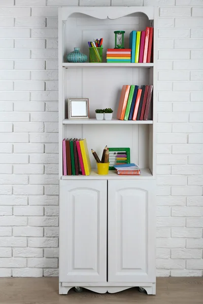 Boeken en decor op planken in kast — Stockfoto