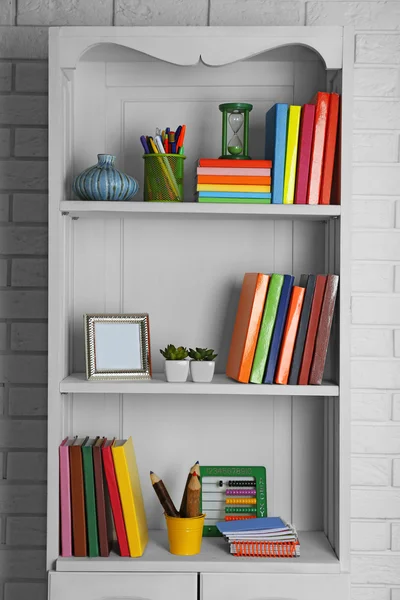 Bücher und Dekoration auf Regalen im Schrank — Stockfoto