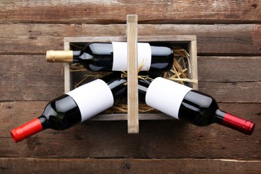 Sepeti ahşap arka plan üzerinde şarap şişeleri