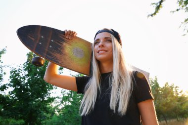 Buz pateni ile genç kadın doğa üzerinde kurulu