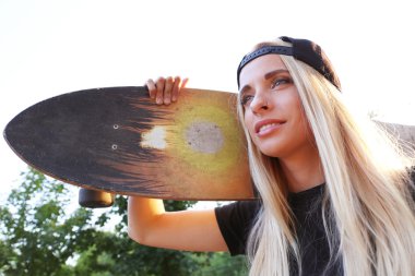 Buz pateni ile genç kadın doğa üzerinde kurulu