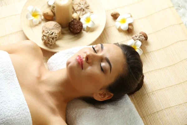 Jovem mulher na mesa de massagem no salão de beleza spa — Fotografia de Stock