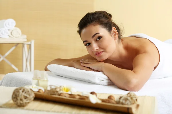 Mujer joven en la mesa de masaje en el salón de spa de belleza —  Fotos de Stock