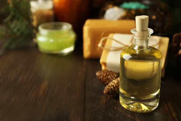 Eterisk olja av tall, handgjord tvål och kräm med tall extrakt och spa behandlingar på trä bakgrund — Stockfoto