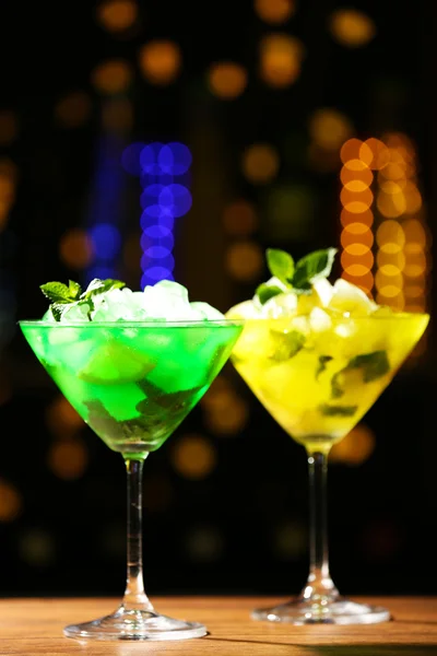 Glasses of cocktail on dark blurred lights background — Stock Photo, Image