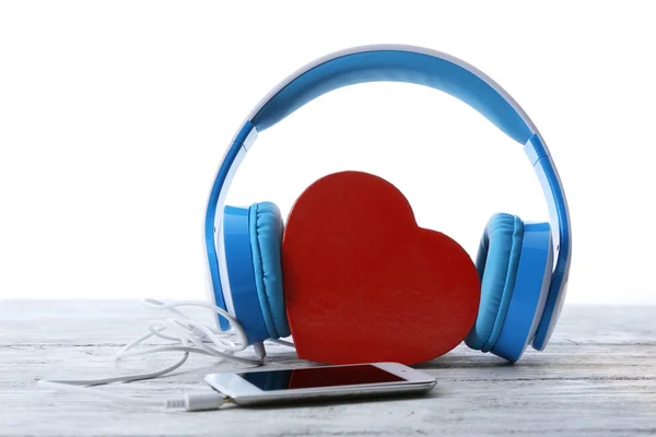 Kalp ve telefon üzerinde beyaz izole mavi kulaklık — Stok fotoğraf