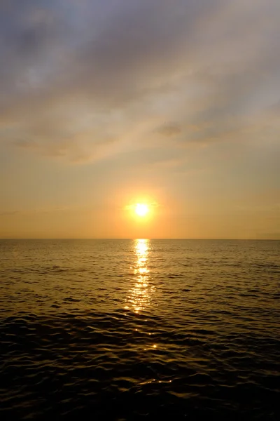 Krásný západ slunce oblohu s mraky nad mořskou vodou — Stock fotografie