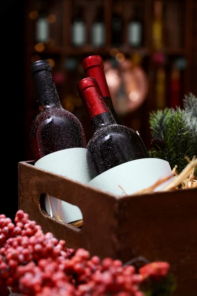 Wine bottles in decorated box on unfocused background — Stock Photo, Image