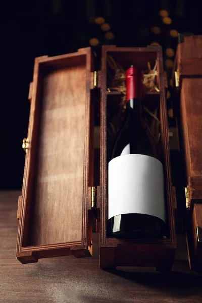 Beautiful wooden case with wine bottle on unfocused background — Stock Photo, Image