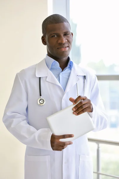 Handsome African American doctor holding digital tablet in hospital — Stock Photo, Image