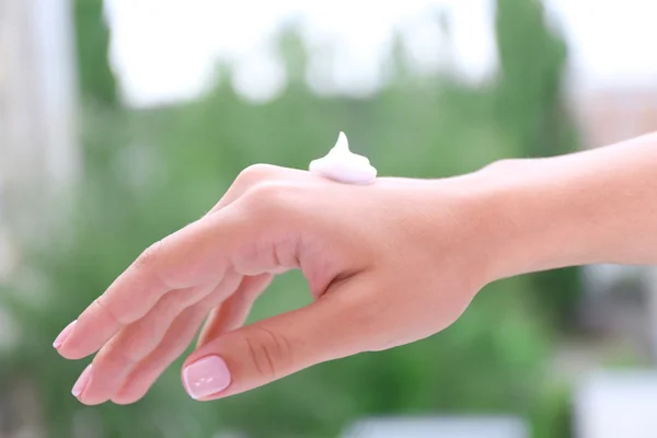Mujeres aplicando crema en sus manos al aire libre —  Fotos de Stock