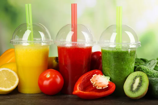 Jugo fresco mezclar frutas, bebidas saludables en la mesa de madera, sobre fondo brillante — Foto de Stock