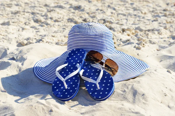Kum plaj portre üzerinde flip floplar, güneş gözlüğü ve şapka — Stok fotoğraf