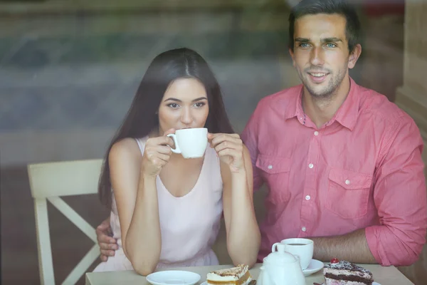 Young couple drinking tea and talking in cafe — Stock Photo, Image