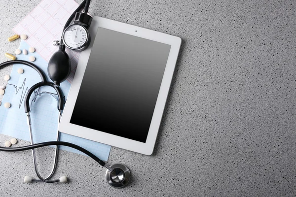 Tansiyon ölçer, stetoskop, gri arka plan üzerinde dijital tablet — Stok fotoğraf
