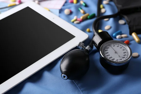 Medidor de presión arterial, estetoscopio, tableta digital sobre fondo oscuro —  Fotos de Stock