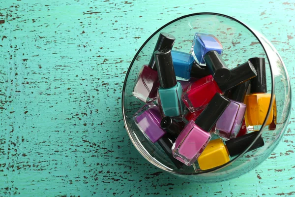 Nail polish set in bowl on wooden table closeup — Stock Photo, Image