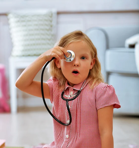 Petite fille jouant avec stéthoscope dans la chambre — Photo