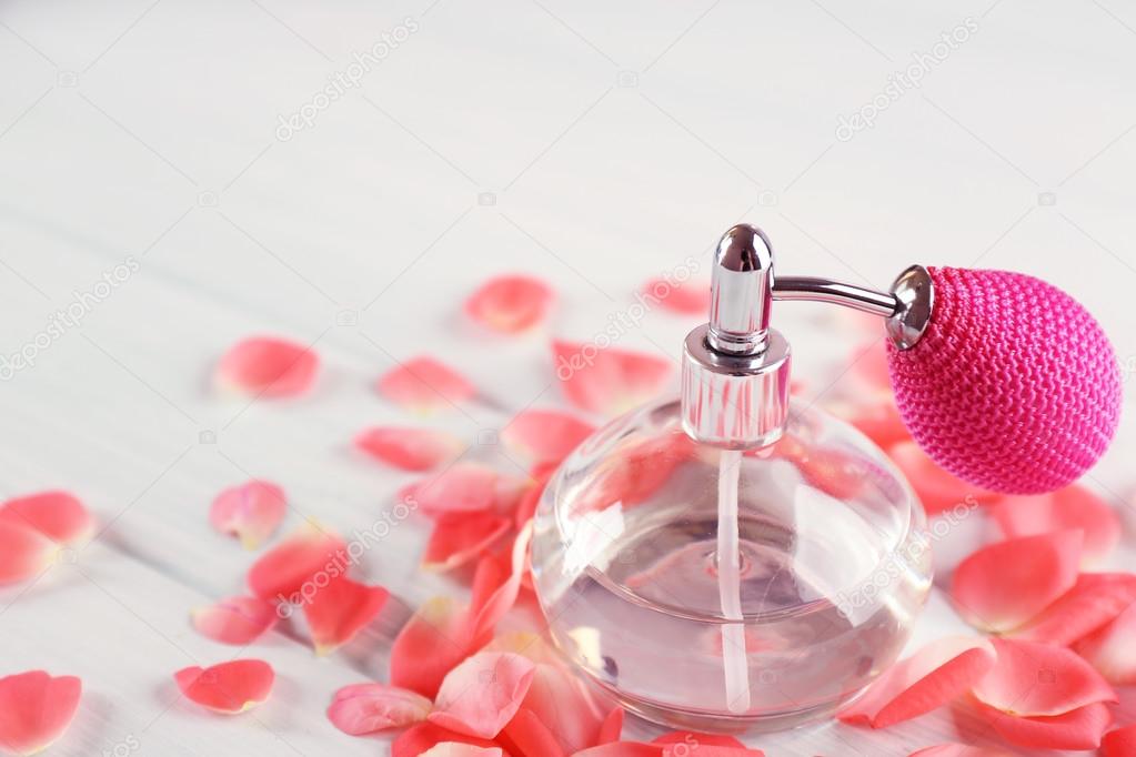 瓶的香水和花的花瓣上木制背景 图库照片 C Belchonock