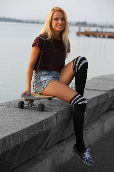 Mujer joven con tabla de patinar —  Fotos de Stock