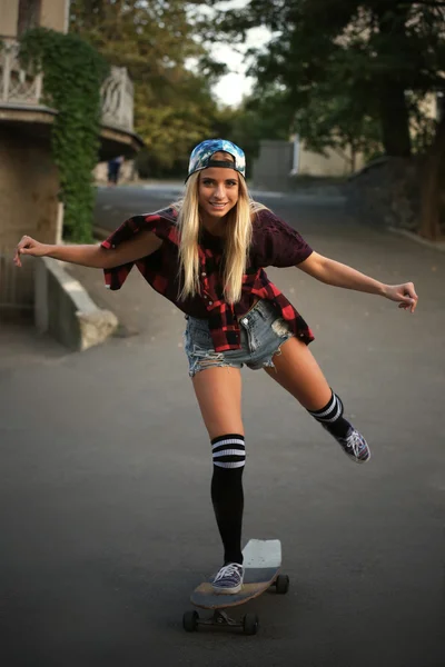 Mujer joven con tabla de patinar — Foto de Stock