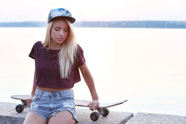 Jonge vrouw met schaatsen board — Stockfoto