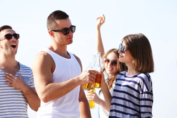 Young people with beer on the riverside — Stock Photo, Image