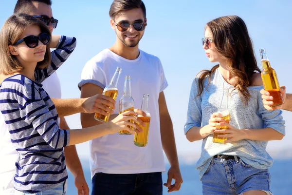 Young people with beer on the riverside — Stock Photo, Image