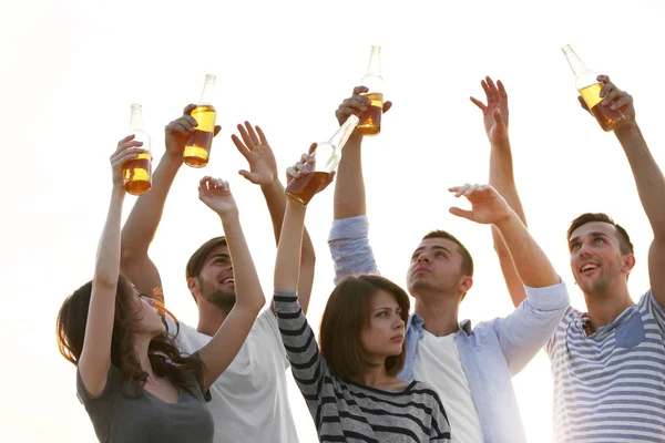 Young people with beer on the riverside — Stock Photo, Image